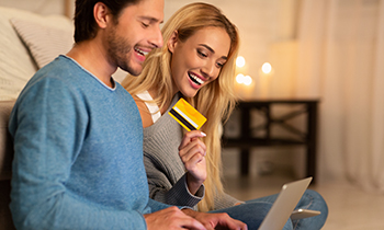 Man And Woman Shopping Holding Laptop And Credit Card Indoor