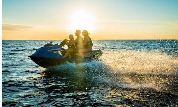 Happy family riding a jetski in the sunset