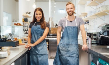 Men and women business owners standing in a kitchen